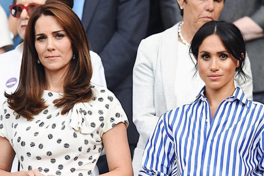 Two women sit side by side in a formal audience setting, looking ahead with composed expressions. The woman on the left wears a white dress with black polka dots and a side bow detail, while the woman on the right wears a blue and white striped blouse with a relaxed collar.