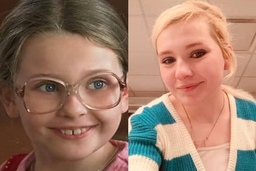Side-by-side images of a woman as a child actress and as an adult. On the left, she is a young girl with light brown hair pulled back, wearing oversized pink glasses, smiling with visible baby teeth, and dressed in a red shirt. On the right, she is older with light blonde hair tied back, wearing black eyeliner and a white-and-teal striped sweater, smiling subtly in a casual indoor setting.