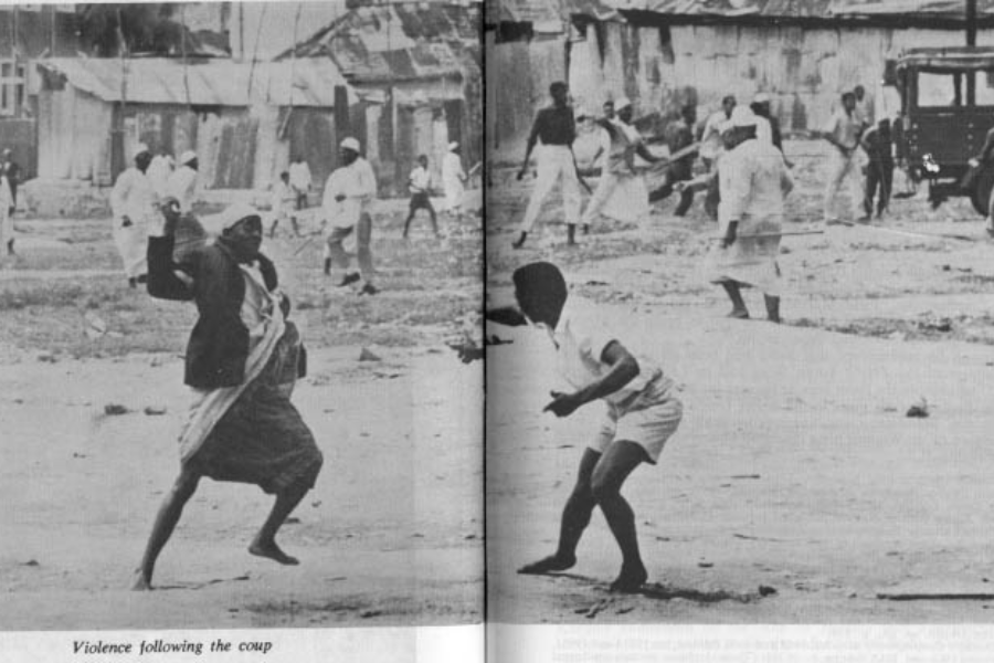 Black-and-white historical photograph capturing a chaotic street scene with civilians engaged in violent clashes, some throwing objects and others wielding sticks. The area appears dilapidated, with rundown buildings and a vehicle in the background. A caption at the bottom reads, “Violence following the coup,” suggesting the image was taken during post-coup unrest.